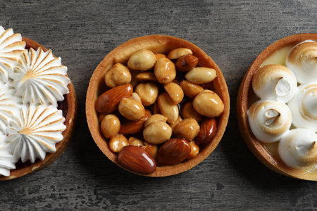 Different tartlets on dark gray table, flat lay. Tasty dessertの写真素材