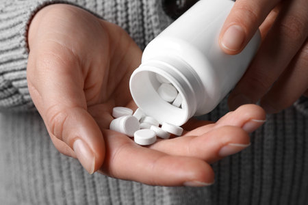 Woman pouring pills from bottle, closeup viewの写真素材