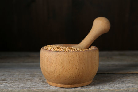 Mortar with mustard seeds on wooden table, closeupの写真素材