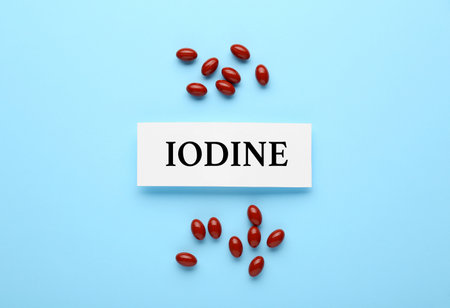 Card with word Iodine and pills on light blue background, flat layの写真素材