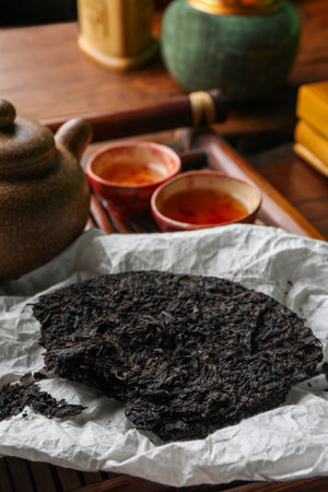 Broken disc shaped pu-erh tea and on tableの写真素材