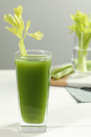 Glass of fresh celery juice on white tableの写真素材