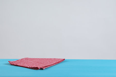 Napkin on light blue wooden table against white background. Space for textの写真素材