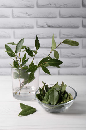 Fresh green bay leaves on white wooden table