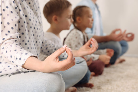 Family meditating together indoors, closeup. Harmony and zenの写真素材