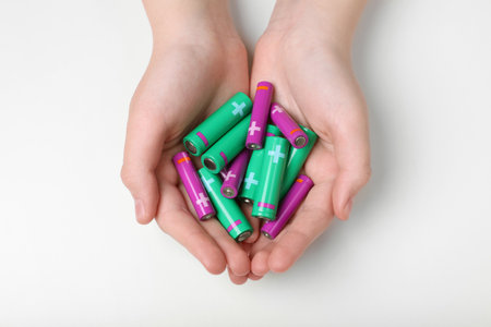 Woman holding many different batteries on white background, top viewの写真素材