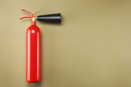 Fire extinguisher on light brown background, top view. Space for textの写真素材