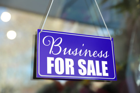 Blue sign with Business For Sale hanging on glass doorの写真素材