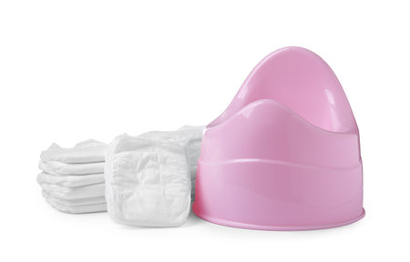 Pink baby potty and stacks of diapers isolated on white. Toilet trainingの写真素材