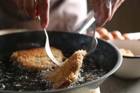 Woman cooking schnitzels in frying pan, closeupの写真素材