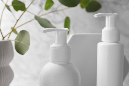 Bottles of face cleansing products and eucalyptus leaves, closeupの写真素材