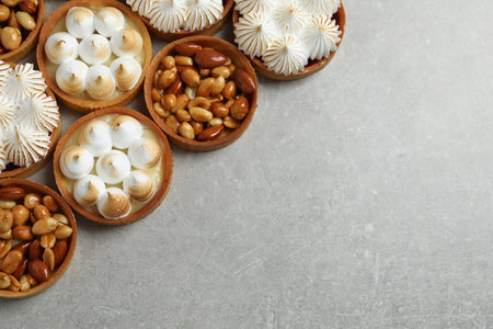 Many different tartlets on gray table, flat lay with space for text. Delicious dessertの写真素材