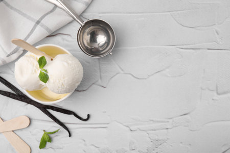Delicious vanilla ice cream served on white textured table, flat lay. Space for textの写真素材