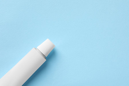 Tube of ointment on light blue background, top view. Space for textの写真素材