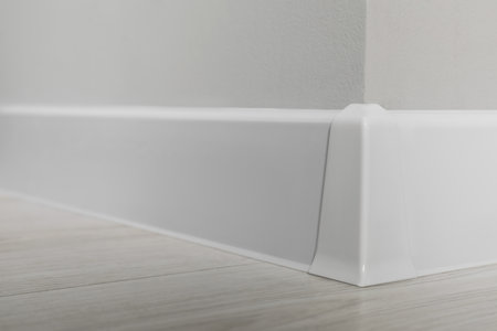 White plinth with connector on laminated floor near wall indoors, closeupの写真素材