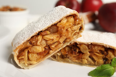 Delicious strudel with apples, nuts and raisins on plate, closeupの写真素材