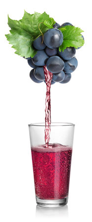 Pouring freshly squeezed juice from grape into glass on white backgroundの写真素材