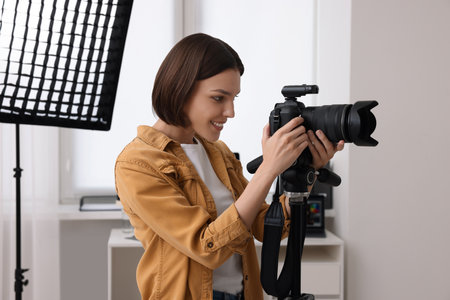 Professional photographer working with camera in modern photo studioの写真素材