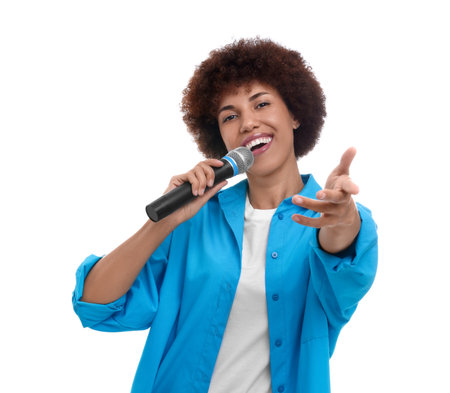 Curly young woman with microphone singing on white backgroundの写真素材