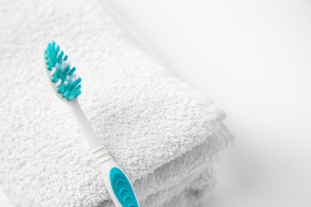Light blue toothbrush and terry towel on white background, closeupの写真素材