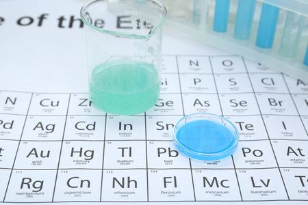 Beaker and Petri dish on periodic table of chemical elements, closeupの写真素材