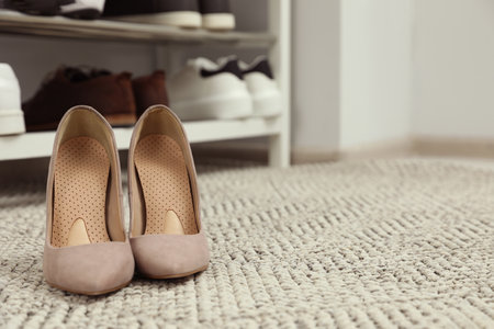 Orthopedic insoles in high heel shoes on rug. Space for textの写真素材