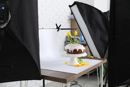 Professional equipment and composition with delicious Easter cake on wooden table in studio. Food...