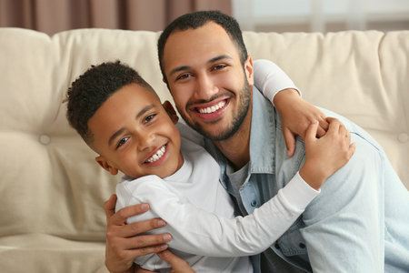 Father with his African American son on sofa. International familyの写真素材