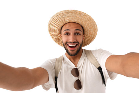 Smiling young man in straw hat taking selfie on white backgroundの写真素材