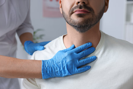 Endocrinologist examining thyroid gland of patient at hospital, closeup