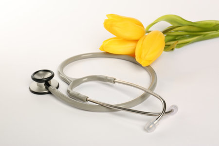 Stethoscope and yellow tulips on white background. Happy Doctor's Dayの写真素材