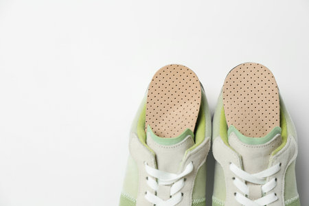 Orthopedic insoles in shoes on white background, closeup. Space for textの写真素材