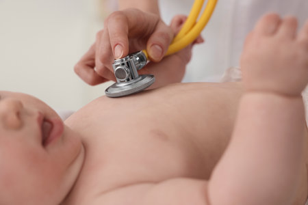 Pediatrician examining little baby with stethoscope in clinic, closeupの写真素材