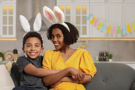 Happy African American mother and her cute son in bunny ears headband indoors. Easter celebrationの写真素材