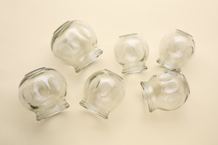 Many glass cups on beige background, flat lay. Cupping therapy