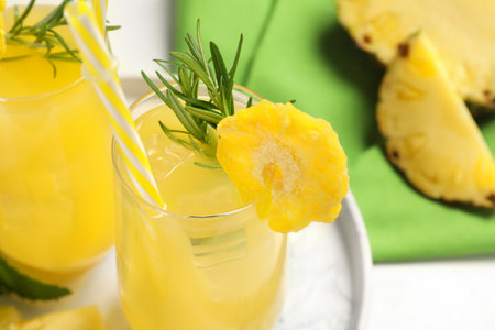 Glasses of tasty pineapple cocktail with rosemary on table, closeupの写真素材