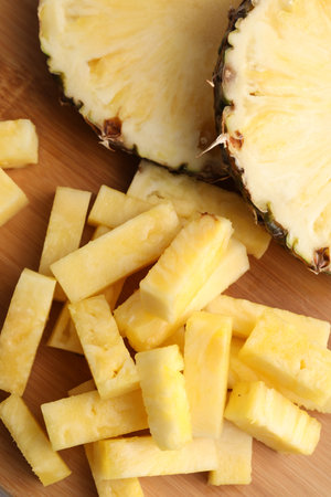 Pieces of tasty ripe pineapple on wooden table, flat layの写真素材