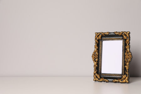 Beautiful vintage empty frame on white table, space for textの写真素材