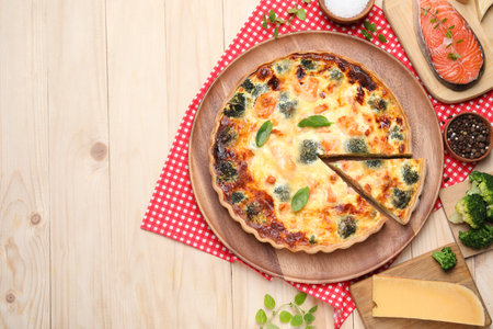 Delicious homemade quiche and ingredients on wooden table, flat lay. Space for textの写真素材