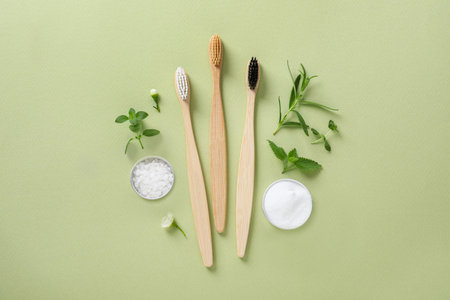 Flat lay composition with toothbrushes and herbs on light olive backgroundの写真素材