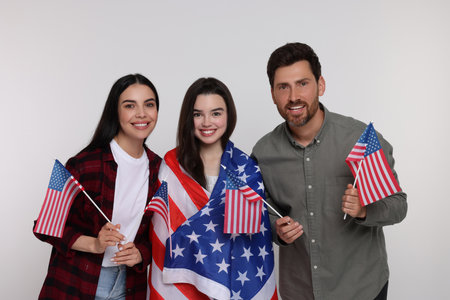 4th of July - Independence Day of USA. Happy family with American flags on white backgroundの写真素材