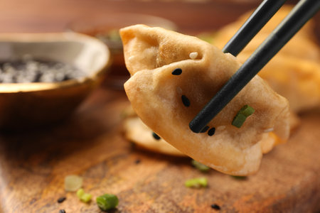 Taking delicious gyoza (asian dumpling) from wooden board, closeup