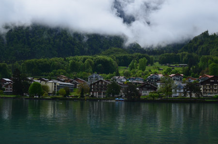 Picturesque view of beautiful village on lake shore near mountainsの写真素材