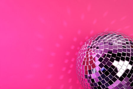 Shiny disco ball on pink background. Space for textの写真素材