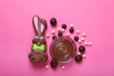 Flat lay composition with chocolate Easter bunny and candies on pink backgroundの写真素材