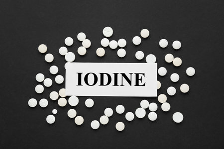 Card with iodine element and pills on black background, flat layの写真素材