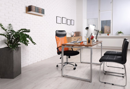 Stylish director's workplace with comfortable desk, computer and chairs for visitors in office. Interior designの写真素材
