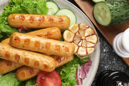 Delicious grilled vegan sausages with fresh herbs and vegetables on gray table, flat layの写真素材