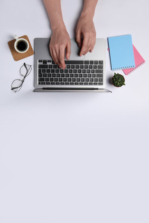 Woman using laptop at white table, top view. Space for textの写真素材