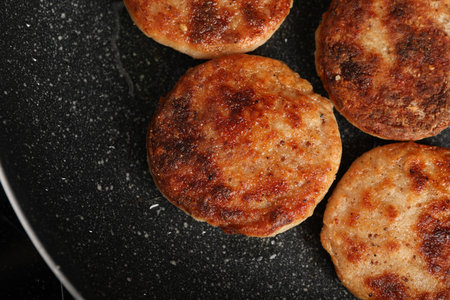 Cooking vegan cutlets in frying pan, top viewの写真素材